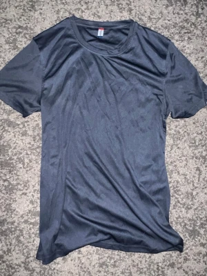 Mörkgrå basic t-shirt - En enkel och stilren mörkgrå t-shirt med rund hals och korta ärmar. Perfekt till jeans eller shorts för en clean look. Tillverkad i mjukt material som känns skönt mot huden.