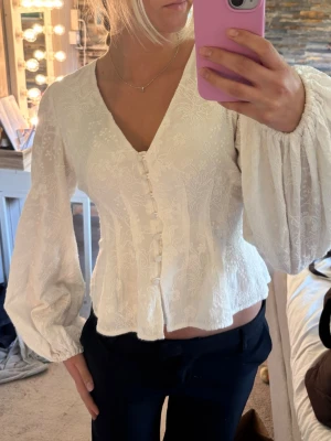 Vit Palena Blus från Adoore - Hej! 🤍Jag säljer en jättefin vit Palena-blus från Adoore i storlek 36. Blusen är sparsamt använd och i väldigt fint skick. Perfekt både till vardags och lite finare tillfällen ✨ Nypris: 1 295 kr.