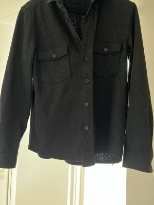 Svart overshirt med bröstfickor - Stilren svart bomullsovershirt. Perfekt nu när det börjar bli lite kyligare. Kan användas både över en t-shirt men också mer som en jacka över hoodies eller skjortor. Märket är mango. Endast testat säljer pga jag inte gillar hur den sitter på mig. Vid fler funderingar elr frågor så är det bara att skriva//Wille