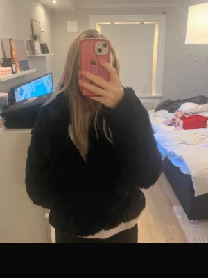Svart pälsjacka från Vila - Säljer en svart fluffig pälsjacka från Vila. Jackan har en klassisk rak passform och är gjord i mjukt fuskpälsmaterial som håller dig varm under kalla dagar. Perfekt för dig som vill ha en stilren och trendig look i vinter.