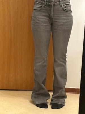 Grå bootcut jeans med hög midja - Säljer ett par gråa bootcut-jeans från Lager 157. De har hög midja, en lätt utsvängd passform nedtill. Väldigt fina och enkla att matcha med olika outfits. De är använda max 3 gånger och är i väldigt bra skick. Det enda är att de är lite slitna längst ner vid bensluten eftersom de var lite för långa för mig, men det syns inte jättemycket och går enkelt att fixa om man vill💕💕💕Nypris 400kr