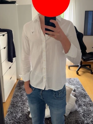 Gant skjorta - Skjortan skickas helt nytvättad och nystruken. Klassisk vit skjorta från Gant med broderad logga på bröstet. Skjortan har lång ärm, knappar framtill och en normal passform. Perfekt till jeans eller chinos för en clean och stilren look. 