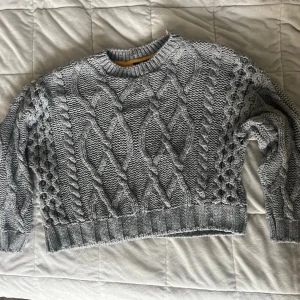 Grå stickad tröja från Topshop - Grå kabelstickad tröja från Topshop med croppad passform, storlek 34 💓 tröjan har två hål under armarna (se bilder), de syns inte framifrån 💕