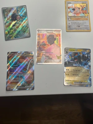 Pokémonkort holografiska och vanliga - Säljer ett set med fem Pokémonkort, bland annat Walking Wake ex, Luxray ex, Cleffa, Professor's Research och Leafeon. Flera av korten är holografiska och har färgstarka motiv. Perfekt för samlare eller Pokémonfans.