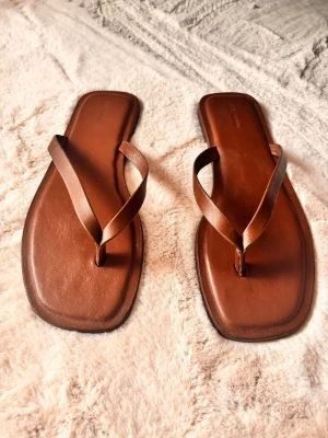 Flipflops i äkta läder - Fina flipflops i brunt läder. Sulan lite sliten men ovansidan i nyskick!