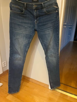 Blå slim fit jeans från Replay - Snygga blå slim fit jeans från Replay med klassisk femficksdesign och diskreta slitningar framtill. Jeansen har normal midja, smala ben och är tillverkade i stretchigt denimtyg. Ny pris 1200 säljes för 399. Längd 30/32 nästan aldrig använda. Vid någon fråga eller fundering slå en signal😊