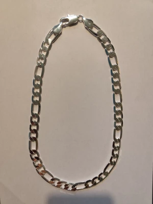 MASSIV FIGARO SILVERKEDJA I 925 STERLING SILVER – 55 CM LÅNG OCH 12 MM BRED - Säljer lite gott & blandat från min smyckessamling från årens lopp, för andra ting i livet:-)  - Vacker tidlös manlig kedja / länk. Som kan ges bort som en omtänksam gåva eller present, födelsedagspresent, dop eller till någon du älskar eller håller kär i livet. Eller unna dig själv.  MER INFO:   FIGARO SILVERKEDJA / HALSBAND MASSIVT  Sterling silver 925.   Längd inklusive karbinlås: ca 55 cm.   Bred: ca 12 mm.   Vikt: ca 67 gram. 