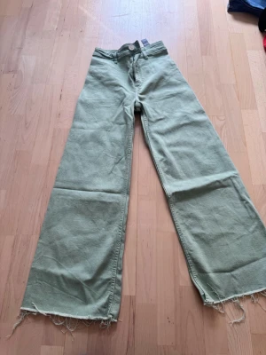 Ljusgröna raka jeans - Snygga ljusgröna jeans med rak passform och klassisk femficksdesign. Jeansen har en enkel look utan slitningar eller dekorationer och är tillverkade i ett mjukt denimtyg som känns bekvämt. Perfekta för dig som vill ha en unik färg på dina jeans.