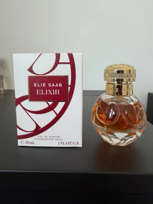Elie Saab Elixir Eau de Parfum 30ml - Elie Saab Le Parfum (Eau de Parfum, 30 ml) är en elegant, feminin och strålande blommig doft. Den öppnar med fräsch appelsinblomma, har ett hjärta av rik jasmin (både Grandiflorum och Sambac) och landar i en varm, lyxig bas av honung, patchouli, cederträ och ros. Flaskan är på 30 ml och endast några enstaka spray har använts.