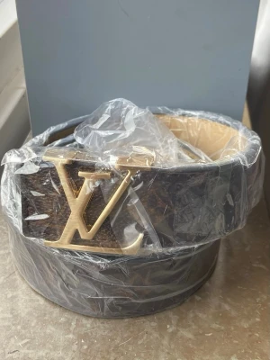 Bälte  - Helt nytt bälte med guld logo. Storlek 110/44. Original förpackning finns inte. Priset kan diskuteras vid snabb affär. 