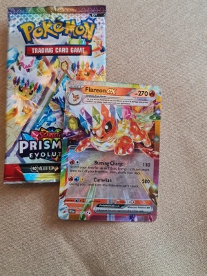Pokémon booster och Flareon ex-kort - Säljer ett Pokémon Scarlet & Violet Prism Booster-pack samt ett Flareon ex holografiskt samlarkort. Kortet har färgstark design med glittriga detaljer och motiv av Flareon. Perfekt för dig som samlar Pokémonkort eller vill boosta din lek.