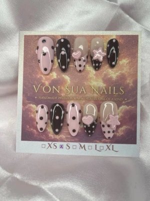 PinkBite (S);Medium Almond - Unika Handgjorda press-on naglar i brunt och ljusrosa med prickigt mönster, rosa handgjorda 3D-charms i form av hjärtan och stjärnor. Medium långa mandelform, perfekt för dig som vill ha en unik och lekfull look.S: 15 mm, 11,5 mm, 12 mm, 11 mm, 9 mm 