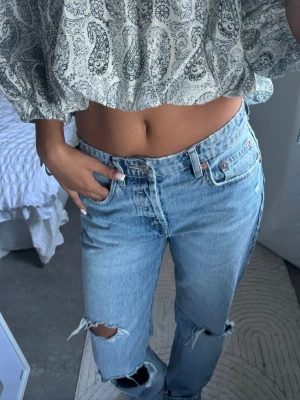 Ljusblå slitna jeans - Säljer ett par ljusblå jeans med hög midja och raka ben. Jeansen har slitningar och hål vid knäna❤️❤️ 
