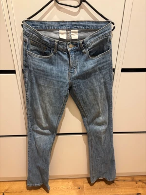 Ljusblå jeans från J.Galt, storlek S - Säljer ett par ljusblå jeans från J.Galt i storlek S. Jeansen har raka ben, klassisk femficksmodell och är tillverkade i 99% bomull och 1% elastan för lite stretch. Snygg tvätt med subtila slitningar och vita sömmar. Perfekta till en avslappnad look. Slitna längst ner kolla sista bilderna. 