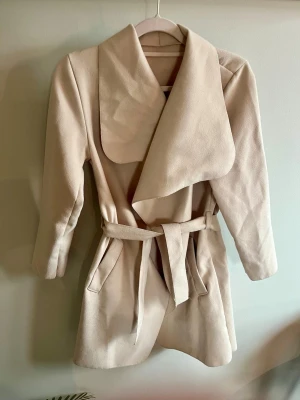 Tunn beige kappa - Jättefint höstig kappa, köpt för några år sedan och tyvärr inte riktigt min stil längre. Stl s-m