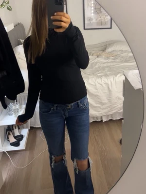 Blå bootcut jeans - Säljer ett par blå bootcut jeans med stora slitningar vid knäna i storlek S. Jeansen har låg midja och klassisk femficksdesign. Dem är i jättebra skick då dem bara har används ett fåtal gånger💕