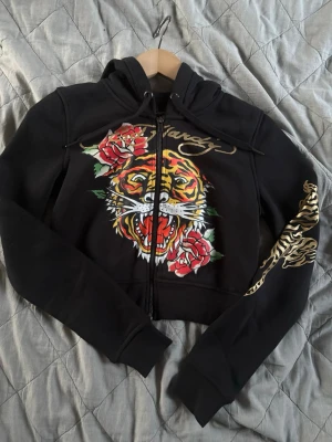 Svart Ed Hardy hoodie med tigertryck - Svart hoodie från Ed Hardy, står s men sitter som xs, ganska kort, aldrig använt 