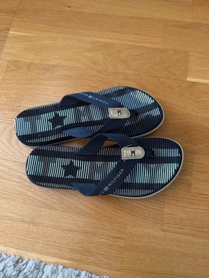 Tommy Hilfiger flipflops - Snygga flipflops ifrån Tommy Hilfiger. Det står ingen storlek men skulle gissa på 36/37. Använda men i gott skick! Hör av er vid frågor💕