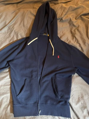 Ralph lauren zip - Ralph lauren zip hoodie. Väldigt schysst marinblå ralph lauren zip hoodie. Finns ett litet märke som syns på bild 1 men inget man tänker på, och syns därmed inte från långa avstånd. Storlek M