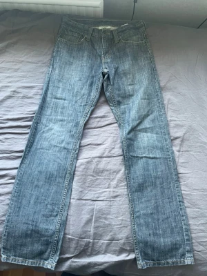 Blå raka jeans från Levi's - Säljer ett par klassiska blågrå jeans från Levi's med rak passform och fem fickor. Jeansen har en ljus tvätt och är tillverkade i slitstark denim. 514. Skriv för fler bilder/funderingar! 