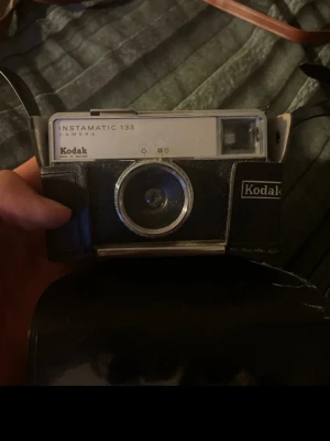 Kodak Instamatic 133 kamera - Säljer en klassisk Kodak Instamatic 133 kamera i svart och silver. Kameran har en retro design med tydliga linjer och är tillverkad i plast och metall. Perfekt för dig som gillar vintageprylar och analog fotografering. Kameran är Otestad men i gott skick
