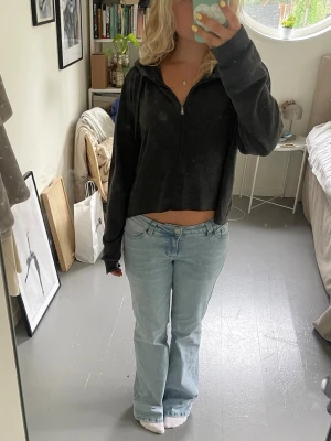 Grå zip tröja  - Säljer en grå hoodie med dragkedja framtill och huva med dragsko. Hoodien har långa ärmar och är gjord i ett mjukt, tunt material som känns skönt mot huden. Perfekt till jeans eller mjukisbyxor för en chill look.