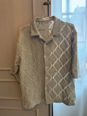 Ljusgrön virkad skjorta från Zara - Säljer en ljusgrön virkad skjorta från Zara i storlek M. Skjortan har ett genombrutet mönster, knappar framtill och krage. Perfekt för lager på lager och ger en avslappnad men trendig look.