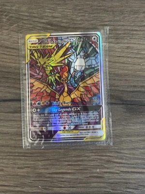 Pokémonkort Moltres Zapdos Articuno GX - Säljer ett Pokémonkort med Moltres, Zapdos och Articuno GX Tag Team. Kortet har en färgstark, holografisk design med mosaikmönster och ligger i plastficka. Perfekt för samlare eller Pokémonfans!