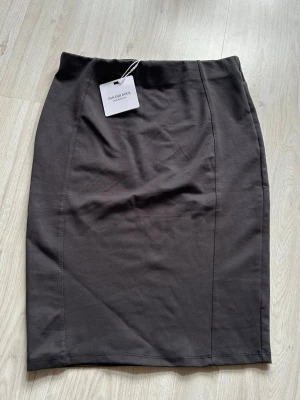 Grå kjol  - Grå kjol i tjockt material storlek medium, men den är ganska liten så passar small även. Resår band har den så den är stretchig vid mage. Ej använd endast provat. Prislapp är kvar   Hel och fin 