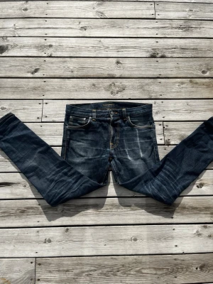 Nudie selvedge jeans lean dean - Storlek 31/32👌🏼Ett par selvedge jeans med naturliga slitningar, och tvätt efter använding. Ger en riktigt schysst look. Vid vänster ficka (tydligast bild 2) ser ni en slitning efter mobiltelefonen, det är en del av designen och sker pågrund av selvedge materialet. Hör av vid frågor eller behov av fler bilder! Mvh Axel