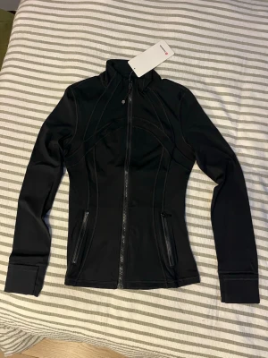 Lululemon jacka svart  - Helt oanvänd och jätte fin svart lululemon jacka som sitter kroppsnära, amerikans storlek 8 vilket motsvarar Medium/eu40, 91cm runt bröstet. 