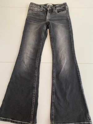 Grå bootcut jeans med slitningar - Säljer ett par grå svarta bootcut jeans med jättesnygga fickor.Dom är från Gina tricot Young och är i storlek 152