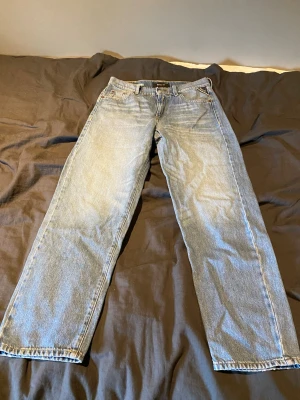 Ljusblå Replay jeans med raka ben - Snygga ljusblå jeans från Replay med raka ben och klassisk femficksdesign. Jeansen har en vintage tvätt och tydliga sömmar, samt Replay-logga på bakfickan och patch bak i midjan. Perfekta för en avslappnad och trendig look.