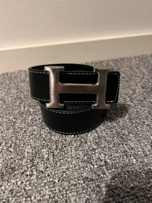 H-bälte  - Snygg svart bälte som passar alla outfits. Storlek:110cm
