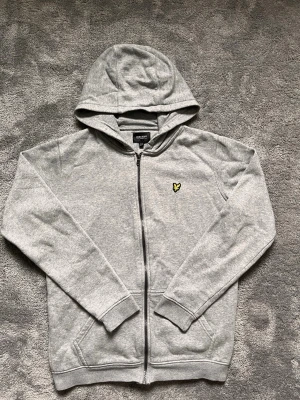 Lyle & Scott Grey Zip Hoodie – Size 12/13 Years (152/158) – Excellent Condition - Classic Lyle & Scott full zip hoodie in grey with the iconic embroidered eagle logo.  ✔ Excellent condition ✔ Full zip fastening ✔ Soft and comfortable fabric ✔ Size: 12/13 Years (152/158) ✔ Perfect for everyday wear  Feel free to message me if you have any questions or would like more photos. Fast shipping!