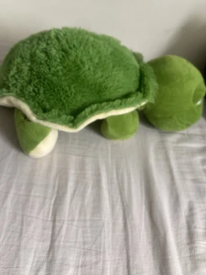 Gosedjur sköldpadda grön plysch - Mysig och mjuk sköldpadda som gosedjur i grön och vit plysch. Sköldpaddan har en fluffig skal och mjuka ben, perfekt att krama eller ha som dekoration i rummet.