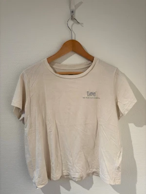 Lee T-shirt  - Cream vit T-shirt med ljusblått tryck från Lee🩵.       Storlek L