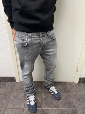 Nudie jeans - Feta grå jeans från Nudie i storlek 32/30. Mycket bra skick. Modell: Grim Tim. A=40CM B=98CM C=16,5CM. Modellen är 173cm, 64kg. Pris kan diskuteras!!