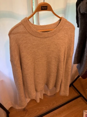 Beige stickad tröja Gina Tricot - Mysig beige stickad tröja från Gina Tricot i premiumkvalitet. Tröjan har rund halsringning, långa ärmar och ribbade muddar. Perfekt för lager på lager och enkel att matcha med olika outfits.
