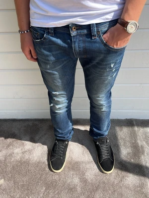 Diesel jeans med slitningar blå - Tjenare! Säljer dessa skit snygga diesel jeansen med gör snygg tvätt, detaljer och slitningar! Mycket gott skick och bra kvalitet! Modellen på bilden är 191cm och väger 79kg som referens. Passformen på jeansen är slim och är i storleken W32/L32. 84%bomull, 14%elastomuliester och 2% elastan. Hör gärna av dig! 