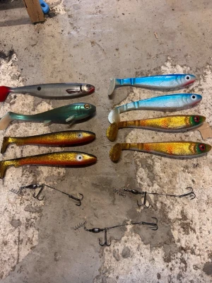 Fiskedrag och stingers mixad färg - Säljer ett set med åtta olika mjuka fiskedrag i färger som blå, grön, silver, guld och röd samt fyra stingers med trekrokar. Perfekt för gäddfiske eller andra rovfiskar. Drag i realistiska fiskformer och glitterdetaljer för extra lockelse.