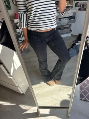 Svarta bootcut jeans med broderi - Säljer ett par svarta bootcut jeans med snyggt broderade bakfickor. Jeansen har låg midja och klassisk femficksdesign. Perfekta för dig som gillar en avslappnad men ändå trendig look.