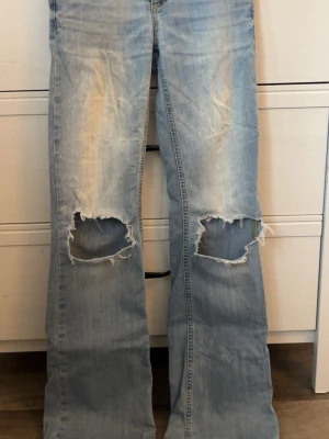 Ljus blåa jeans med fickor bak med lock - Ljus blåa jeans med fickor bak med lock från Nelly, säljs för att jag inte använder, tyvärr vita sträck på dom som blivit av tvättmaskinen. Annars superfina 