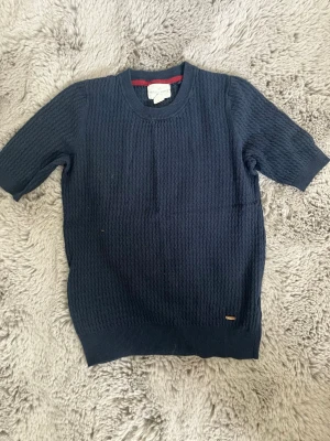 Mörkblå stickad tröja kort ärm - Snygg ribbad mörkblå tröja från Holly & White i storlek Xs/34. Den är använd några gånger🤍