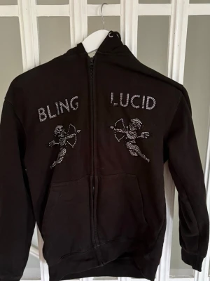 Zip Bling Lucid - Säljer en snygg Zip tröja från Bling Lucid i storlek S. Den har tappat några stenar men ser ändå snygg ut.