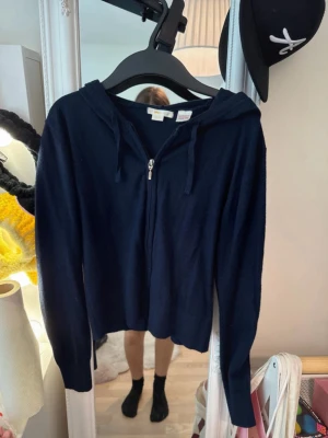 Mörkblå zip hoodie med huva - Snygg mörkblå hoodie med dragkedja framtill och huva med snören. Långärmad och i mjukt material som känns skönt mot huden. Perfekt för en avslappnad och chill stil.
