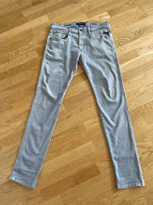 Ljusgråa slim fit jeans - Snygga ljusgråa slim fit jeans med klassisk femficksdesign och smala ben. Jeansen har bälteshällor och dragkedjegylf. Perfekta för dig som gillar en stilren och modern look. Materialet är mjukt och stretchigt för extra komfort.