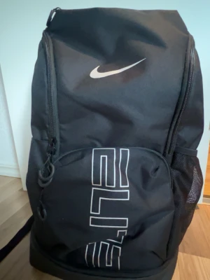 Nike Elite Väska - VARSITY ELITE UNISEX Köpt på Zalando för basket, 929kr! Köptes innan sommaren, använde ungefär en gång, har inga som helst defekter eller smuts utan fortfarande i nyskick. Går att använda till gym, sport, eller skolan då den har många passande fack. Skriv för fler detaljer frågor eller bilder!! 