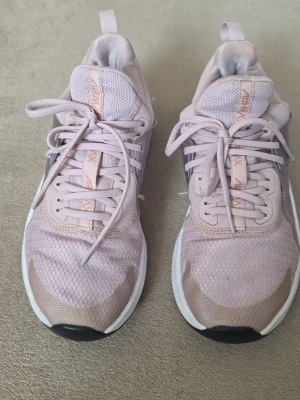 Nike Air Max löparskor/ träningsskor i rosa, storlek 37.5 - Begagnade träningsskor – inga hål eller revor, bara några fläckar. De är mycket bekväma. Ett par Nike Air Max löparskor i rosa. Skorna har snörning och en vit sula med svarta detaljer. Det finns synliga tecken på användning, inklusive missfärgningar på sulan och slitage på materialet
