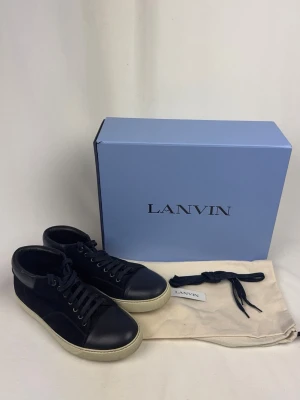Lanvin Sneakers  - 🌸 INFO OM PLAGGET 🌸  ☑️ Märke: Lanvin ☑️ Storlek: 42 ☑️ Färg: Mörkblå ☑️ Skick: ⭐⭐⭐⭐⭐️/ Aldrig Använda  ✨ Detaljer: ☐ Inga hål ☐ Inga fläckar ☐ Nytvättad ☐ Rökfritt hem ☐ Djurfritt hem  📏 Passform: ☑️ Normal   📦 Skickas snabbt. 💬 Skriv gärna om du vill ha fler bilder eller mått. 🤍 Paketrabatt vid köp av flera annonser. 🌟 Titta gärna på mina andra annonser!